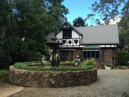 Cedar Creek Vineyard North Tamborine Wine bottle on top of Wine Barrel in front of Cedar Creek Main Building