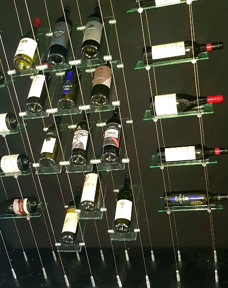 Floating glass wine rack system display with wine bottles filled Floating glass wine rack system display with wine bottles filled